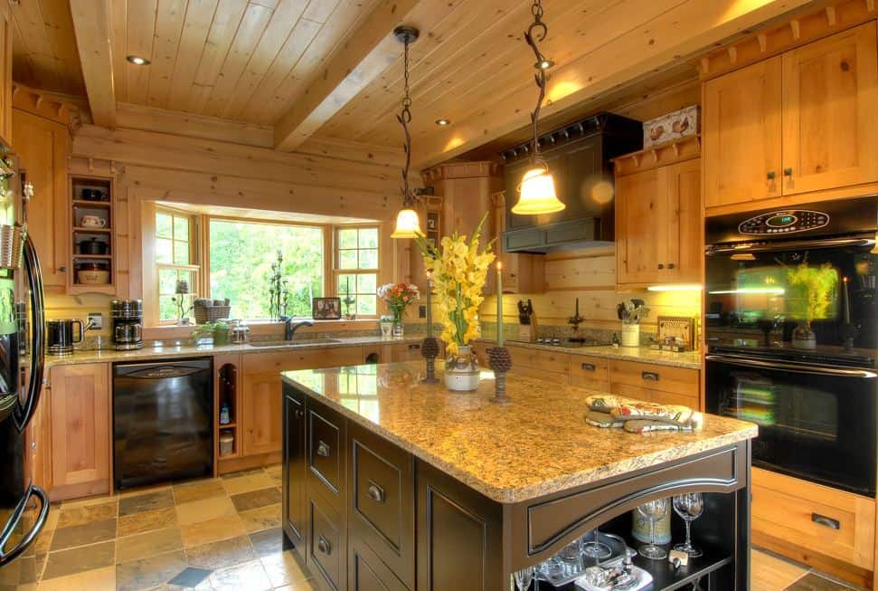 Photo of a kitchen with granite counters and black appliances