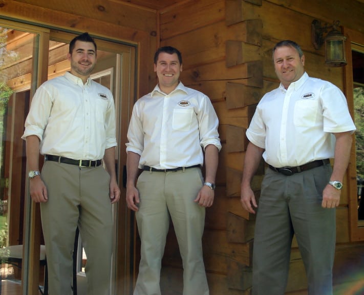 Photograph of Rich, Andy and Rick Kinsman standing in on the porch of an 1867 Confederation Log & TImber Frame home