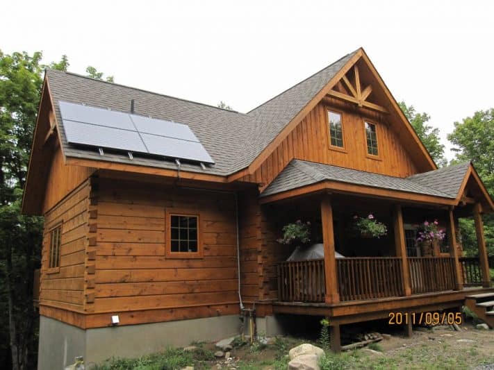 Off the grid log home with solar panels.